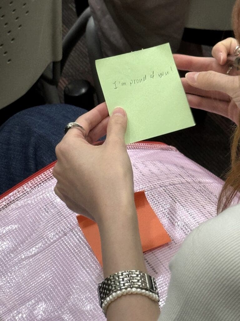 A participant holding a sticky note during a workshop